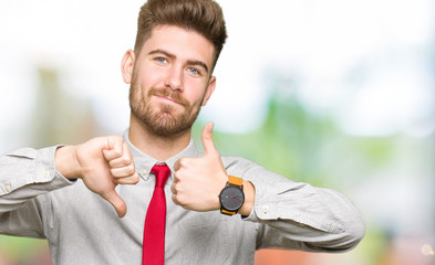 Young handsome business man Doing thumbs up and down, disagreement and agreement expression. Crazy...