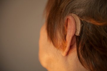 elderly retired woman with hearing impairment received hearing aid of latest modification in center...