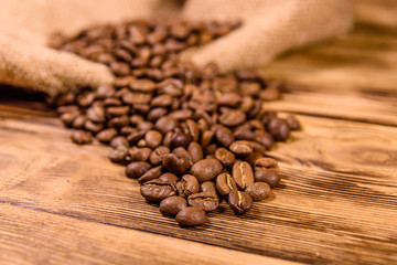 Sackcloth and scattered coffee beans on wooden table