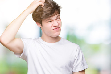 Young handsome man wearing casual white t-shirt over isolated background confuse and wonder about...