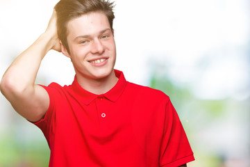 Naklejka premium Young handsome man wearing red t-shirt over isolated background Smiling confident touching hair with hand up gesture, posing attractive