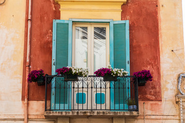 Italy, Apulia, Province of Barletta-Andria-Trani, Trani. Samll balcony with ddors and blue shutters.