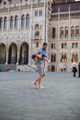 Fototapeta na wymiar dad and little daughter are walking in the square near the Hungarian Parliament 1