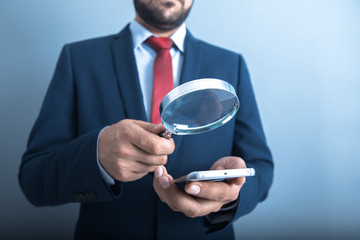 man hand magnifier and phone