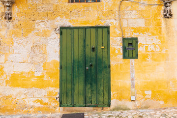 Italy, Basilicata, Province of Matera, Matera. Green door in a yellow wall.