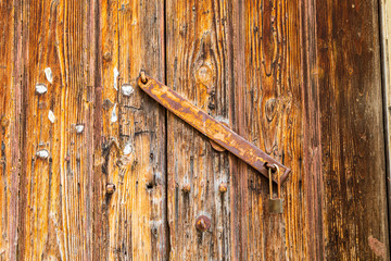 Italy, Apulia, Province of Lecce, Lecce. Deatil of old weathered wooden door with bar and lock.