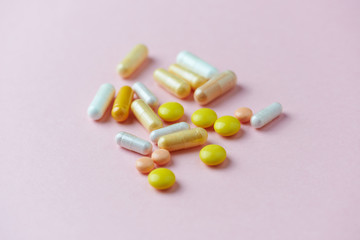 Vitamins and supplements on bright paper background. Concept for a healthy dietary supplementation. Close up. Copy space. 