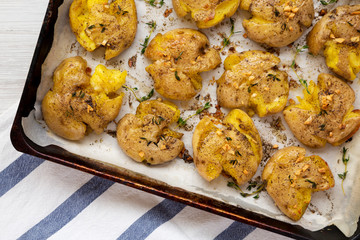 Homemade garlic thyme smashed potatoes, top view. Flat lay, overhead, from above. Close-up.
