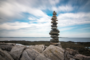 Fototapeta na wymiar Balanced tower of rocks on the coast 