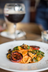 Italian dish, Linguine pasta with tomato sauce, green olives and roasted tomato