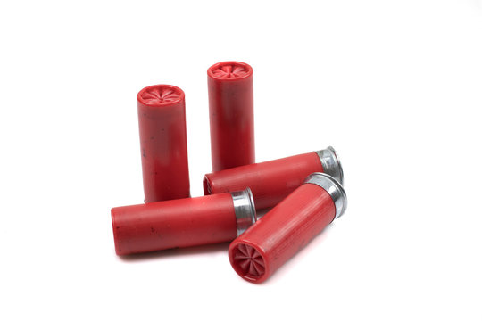A close up image of a red shotgun shells, shot close up in macro, isolated on a clean, white background