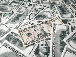 Many hundred dollar bills and one 10 dollar bill.. The concept of sustainable world currency rates. USD close-up photo. Finance and economics.