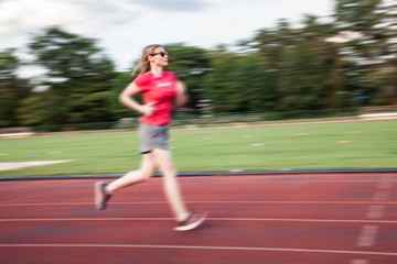 Obraz premium young woman on running track motion blur