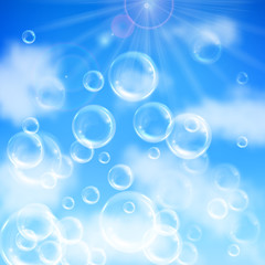 Realistic transparent floating soap bubbles on blue sky background. Design element for advertising booklet, flyer or poster