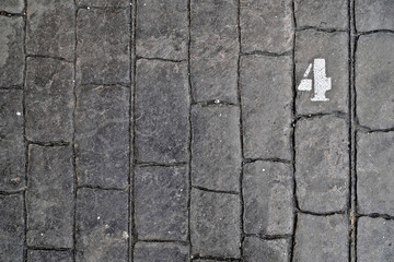 4, number four, white stencil number on cobblestone surface.