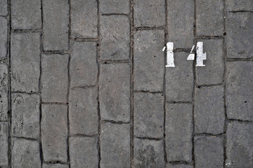 14, number fourteen, white stencil number on cobblestone surface.