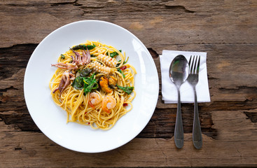 Sea spaghetti food delicious put on a white plateon a wooden background from top view.