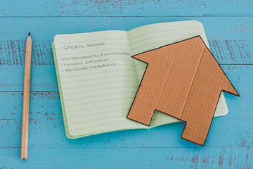 green home checklist, miniature house on notepad