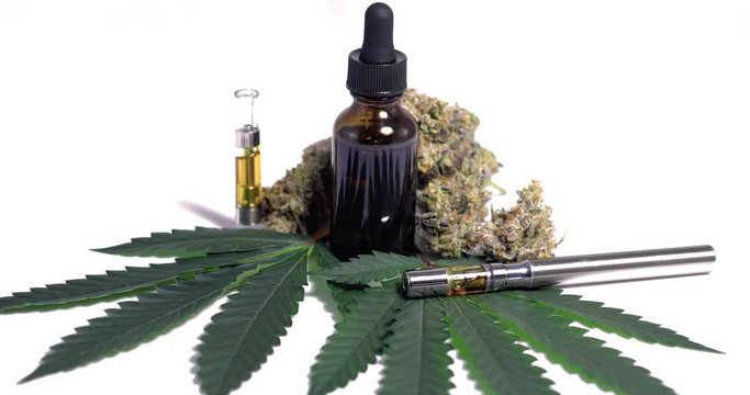 Marijuana CBD Oil Display of Vaperizor and Veil by Leaves and Buds