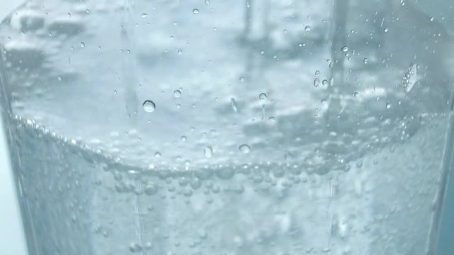 固定撮影した炭酸水の入ったコップに炭酸水を注ぎ足した瞬間