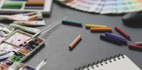 Professional artist workplace with water colours, soft pastel colours and painting brushes