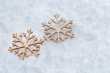 Christmas background with Two wooden snowflakes on snow. Christmas decoration. Holiday winter background.