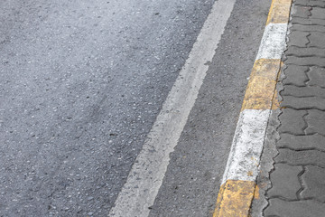Fototapeta premium Yellow and white lines on footpath