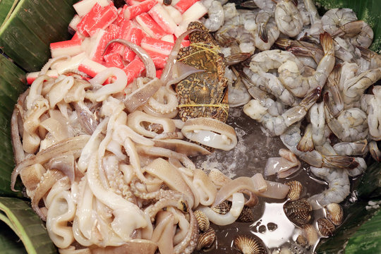 Ready to cook raw fish shrimp cuttlefish cockle crab in banana leaf  on cold ice