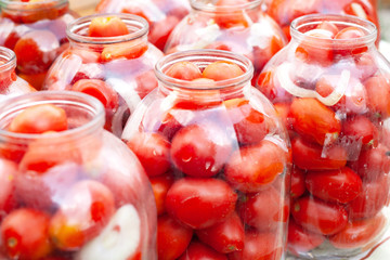 Fototapeta na wymiar pickled (canned) red tomatoes in jars