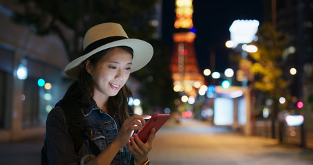 Obraz premium Woman use of mobile phone in city at night