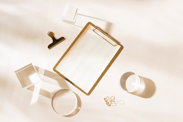 Knolling grid flatlay scene, white planner and gold stationery accessories, on a white desk background