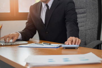 Business woman working in office with checking business report in a tablet. using a tablet computer for money analyzing graphs