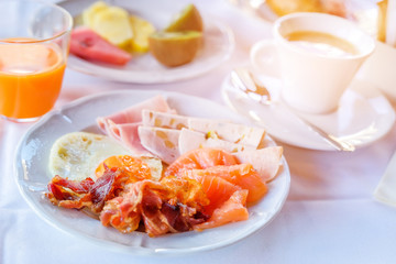 Delicious breakfast served with coffee, orange juice, egg, ham, bacon rolls at the luxury hotel