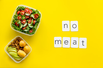 Healthy dinner in lunch box and no meat text on yellow background top view