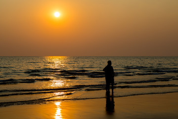 Siluate lovers and beach before sunset