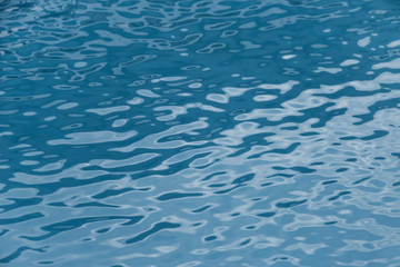 Blue swimming pool edge with refection of water ripple