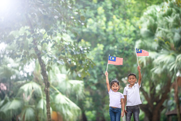 Boy and Girl with Malaysia Flag. Independence Day concept. Outdoor Setting