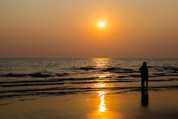 Siluate lovers and beach before sunset