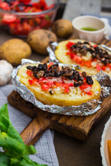 Baked stuffed potatoes with vegetables in foil. Homemade vegan food. 