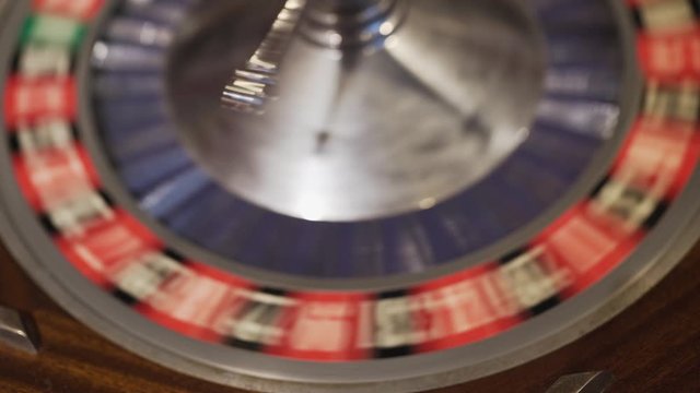 A spinning Roulette wheel with the ball landed on one of the numbers. One lucky winner will take it all.