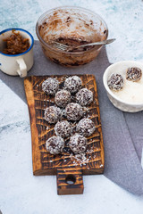 Coconut sweet balls with ingredients on table. Energy protein dessert with dates, cocoa, peanut butter.