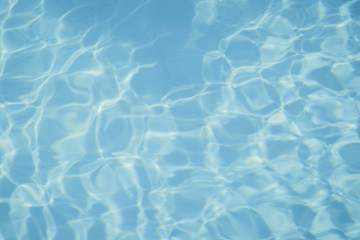 Obraz premium Niebieska woda w basenie z refleksami słońca
