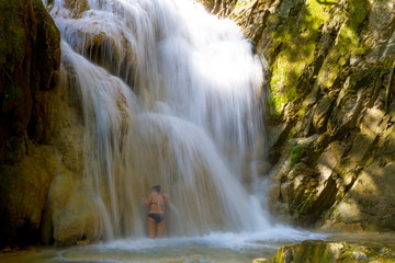 Woman with bikini black enjoy water at Erawan Waterfall