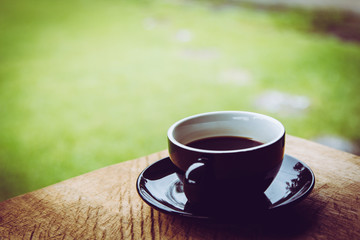 Coffee cup on old wooden table with nature background