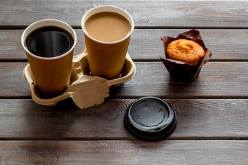Coffee to take away, muffin on wooden background. Translation of the Russian text on the lid is Caution: contents hot.