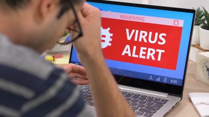 Getting a warning about a virus being detected on a laptop portable computer screen.