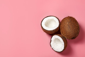 Fototapeta na wymiar Cracked coconuts on pink background.
