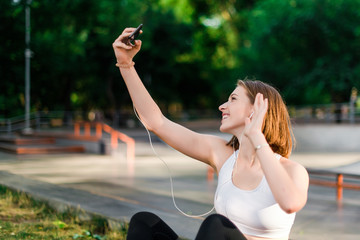 teenage girl making selfie and using phone in the park