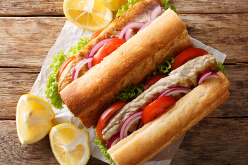 fast food sandwich balik ekmek with grilled mackerel served with lemon closeup. Horizontal top view
