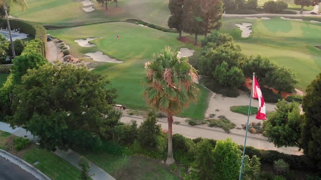 Footage of the Canadian Flag waving in the wind near an upscale golf course in West Los Angeles